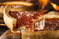 Deep-dish pizza slice revealing gooey cheese and rich tomato sauce, highlighting Chicago's iconic food in relation to dental health discussion.