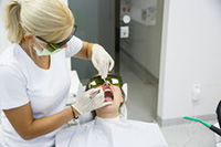 Dental professional performing laser gum removal treatment on a patient, showcasing the procedure's virtually painless nature in a modern dental office.