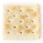 Saltine cracker highlighting processed starches, associated with dental health risks and bacteria growth, as discussed in the context of harmful foods for teeth.