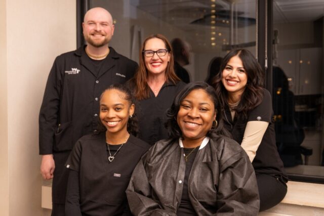 Dental clinical team at Water Tower Dental Care, featuring five smiling professionals in black uniforms, showcasing a warm and welcoming atmosphere.